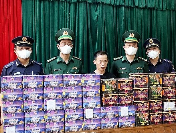 Đối tượng (đứng giữa) cùng tang vật khi bị bắt giữ. 
