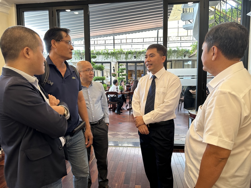 Trưởng phòng Giám quản lý về hải quan Vương Tuấn Nam trao đổi với DN bên lề hội nghị. ảnh: T.H