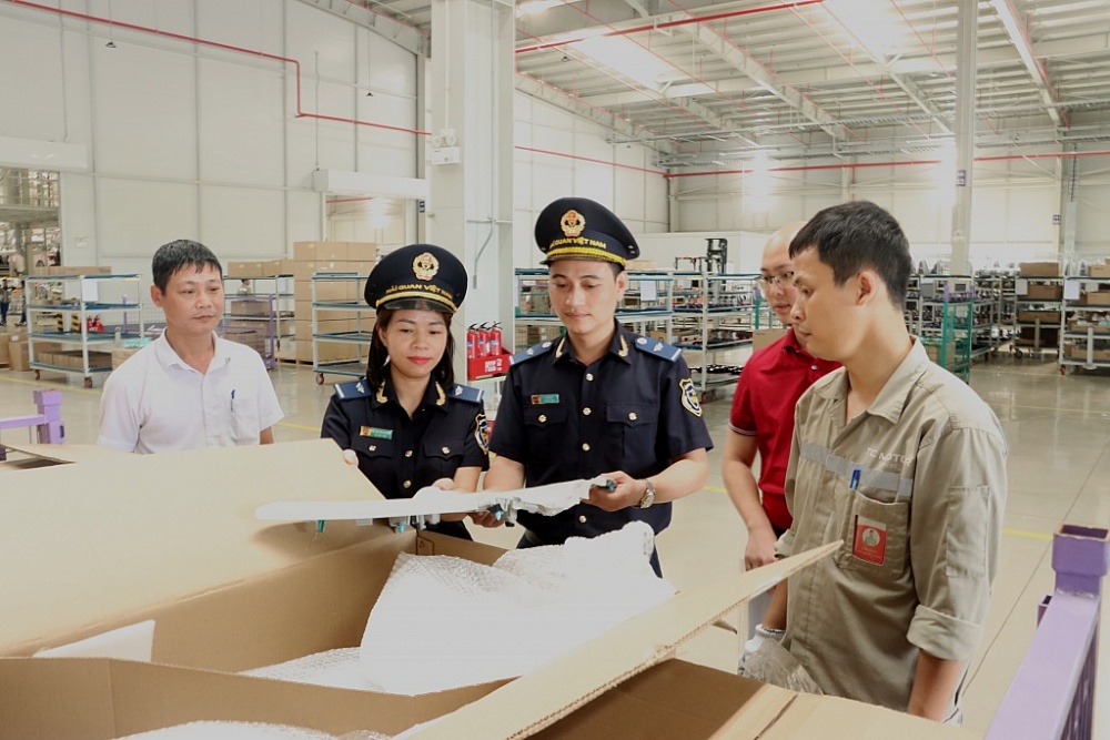 Công chức Hải quan Ninh Bình (Cục Hải quan Hà Nam Ninh) kiểm tra nguyên liệu phụ liệu NK trong hoạt động sản xuất của DN. Ảnh: H.Nụ