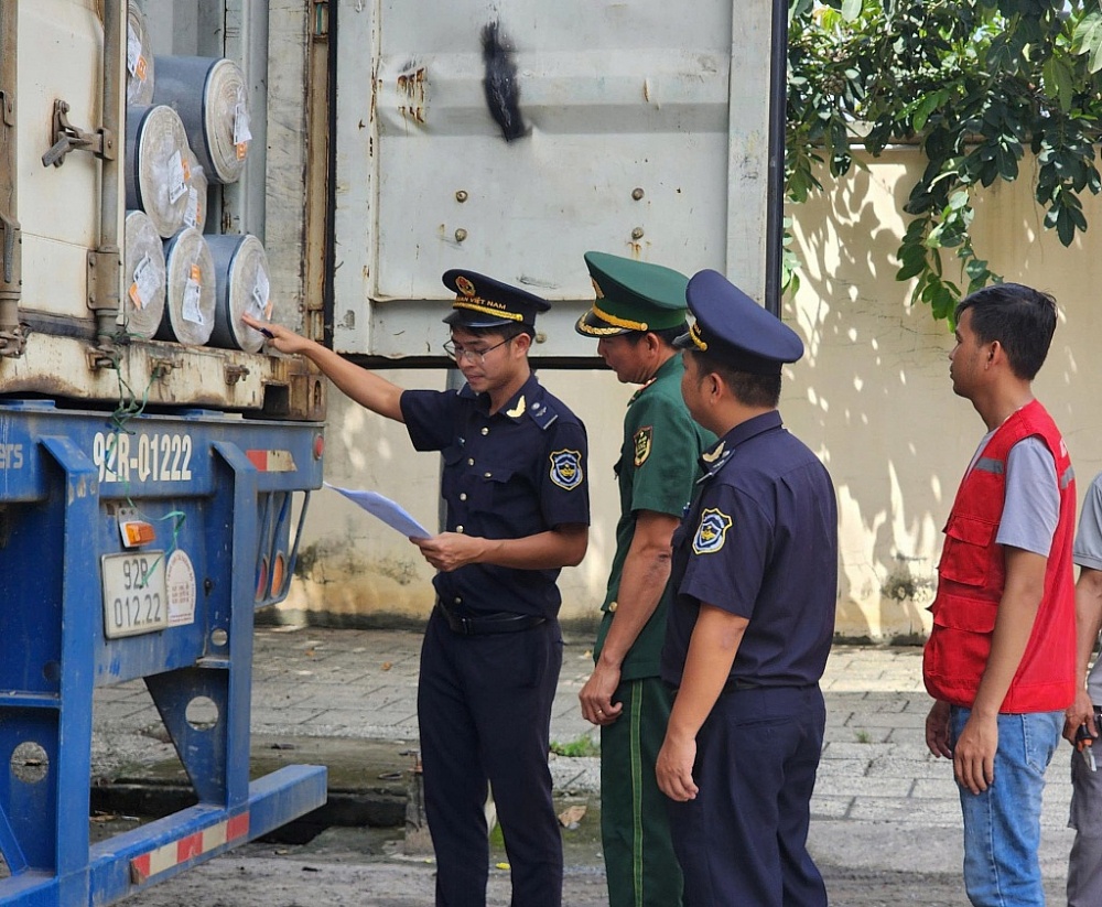 Công chức Hải quan cửa khẩu quốc tế Mộc Bài phối hợp với lực lượng biên phòng kiểm tra hàng hóa xuất khẩu sang Campuchia. Ảnh: T.D