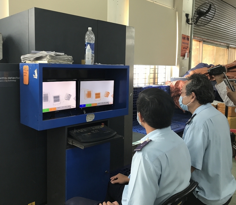 Công chức Hải quan Chuyển phát nhanh kiểm tra hàng hóa NK qua máy soi. 	Ảnh: T.H