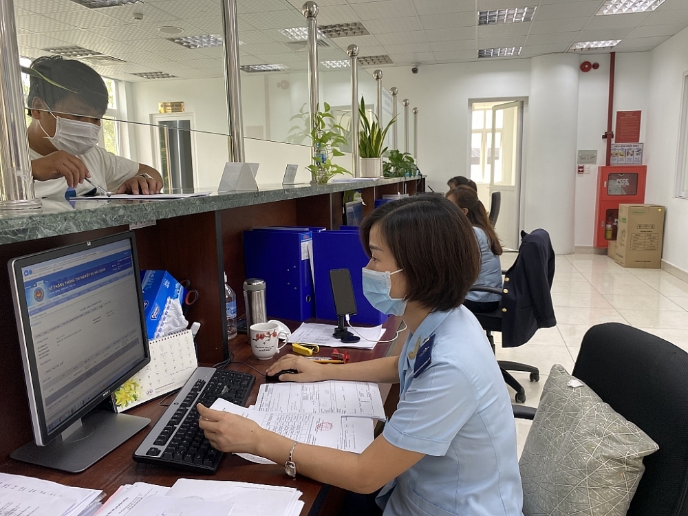 Công chức Cục Hải quan Bình Dương làm thủ tục XNK cho doanh nghiệp.	 Ảnh: T.D