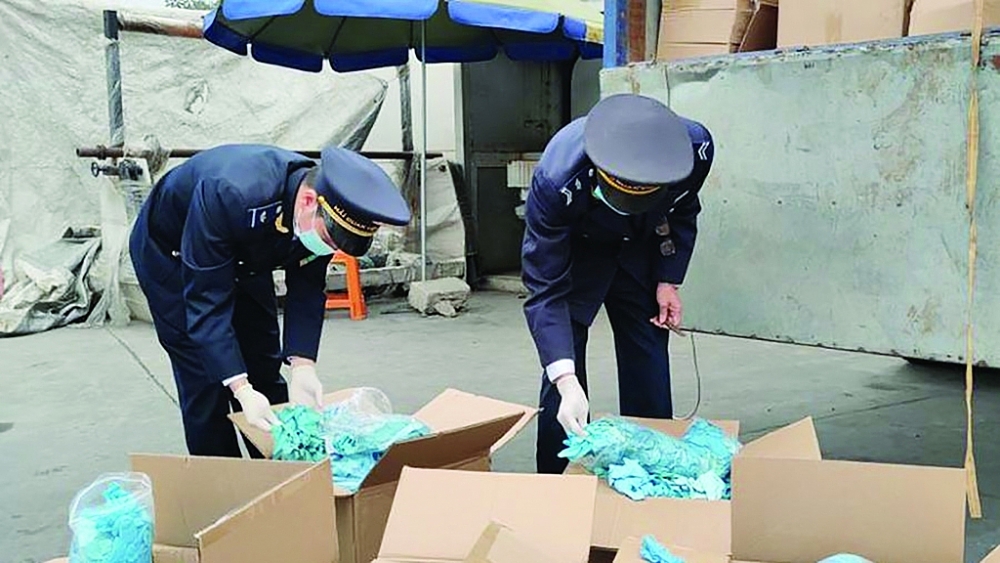 Công chức Hải quan Hữu Nghị (Cục Hải quan Lạng Sơn) kiểm tra lô hàng găng tay đã qua sử dụng của Công ty TNHH Ngọc Diệp. 	Ảnh: Thành Nguyễn