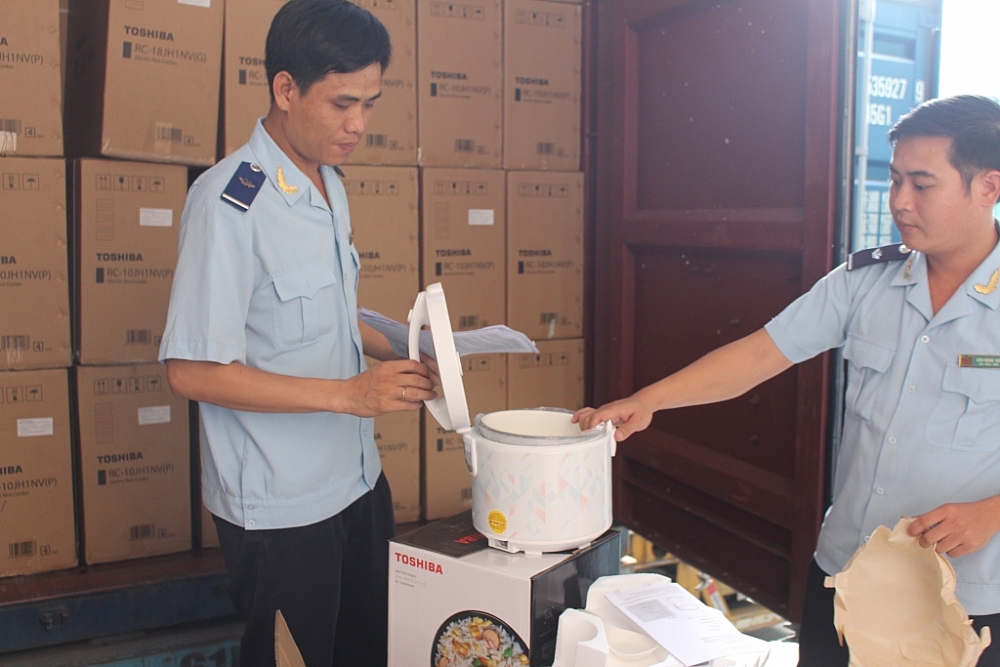 Công chức Chi cục Hải quan Quản lý hàng hóa XNK ngoài KCN, Cục Hải quan Bình Dương kiểm tra lô hàng nồi cơm điện nhập khẩu vi phạm xuất xứ. 	Ảnh: Thu Dịu