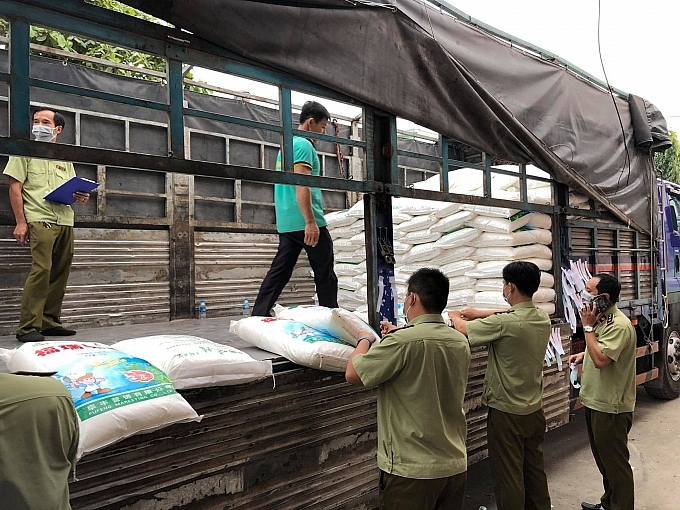 Lực lượng chức năng khám xet hàng hóa vi phạm.