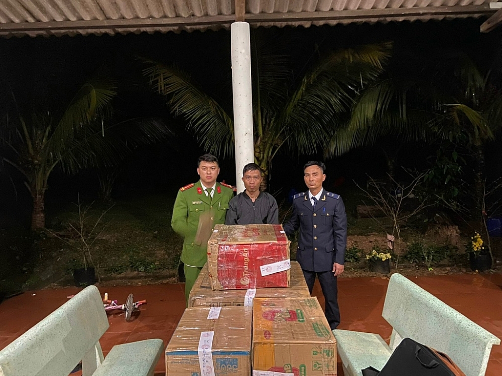 Một trong hai đối tượng (đứng giữa) cùng tang vật. 