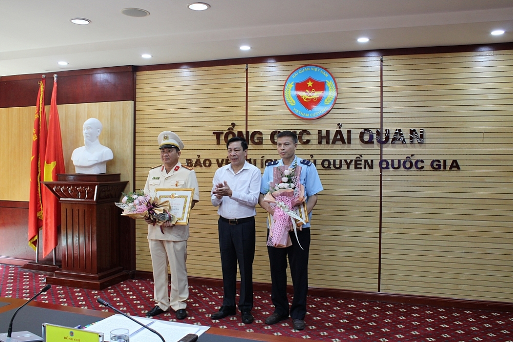 Phó Bí thư thường trực Đảng ủy Bộ Tài chính trao huy hiệu 30 năm tuổi Đảng cho 2 đảng viên. Ảnh: Q.H