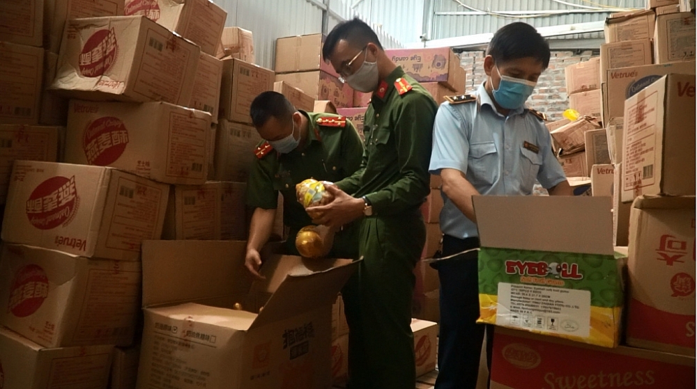 Lực lượng chức năng phối hợp kiểm tra kho chứa bánh kẹo.