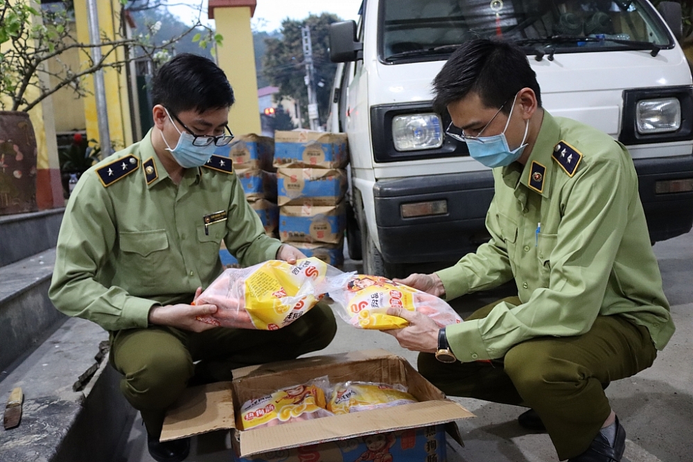 Lực lượng chức năng kiểm tra số hàng vi phạm. Ảnh: QLTT LS