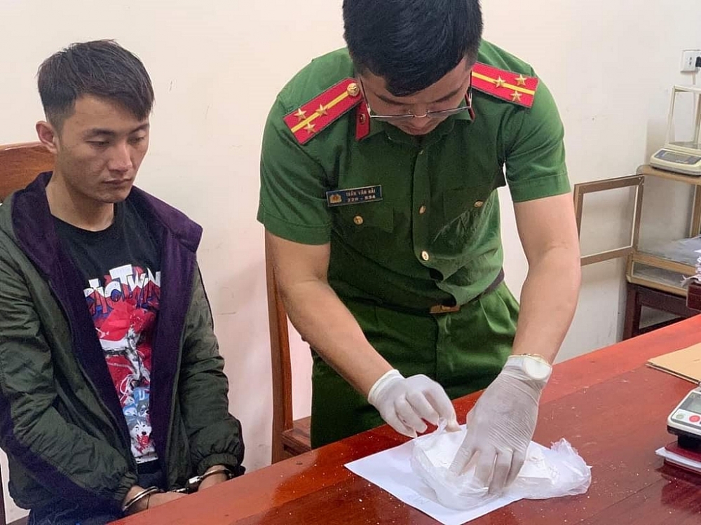 Đối tượng (ngồi) cùng tang vật tại cơ quan điều tra. Anhr: CA NA
