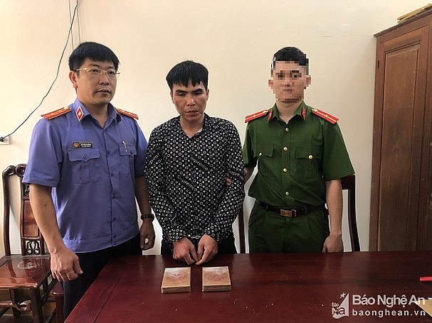 Đối tượng (đứng giữa) cùng tang vật. Ảnh: CA NA