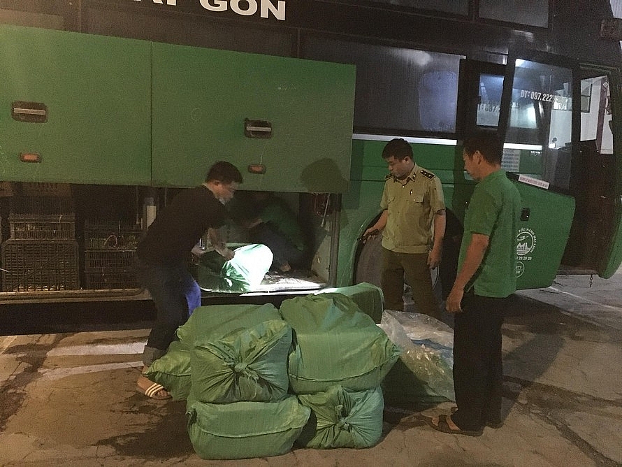 Lực lượng chức năng kiểm tra số hàng vi phạm. Ảnh: QLTT NA
