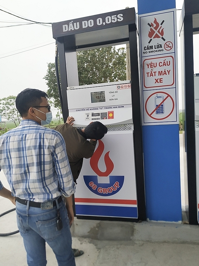 Lực lượng chức năng kiểm tra cửa hàng xăng dầu vi phạm. Ảnh: QLTT NB