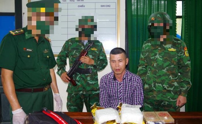 Đối tượng (ngồi) cùng tang vật khi bị bắt giữ. Ảnh: Thanh Giang