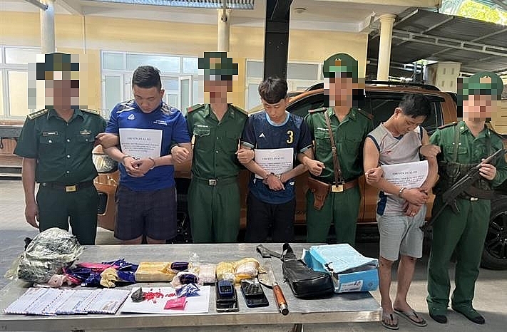 Các đối tượng Nguyễn Tất Hùng, Southammavong Zaloun và Lobouaphone MaiChanh cùng tang vật. Ảnh: Phan Thanh Lịch
