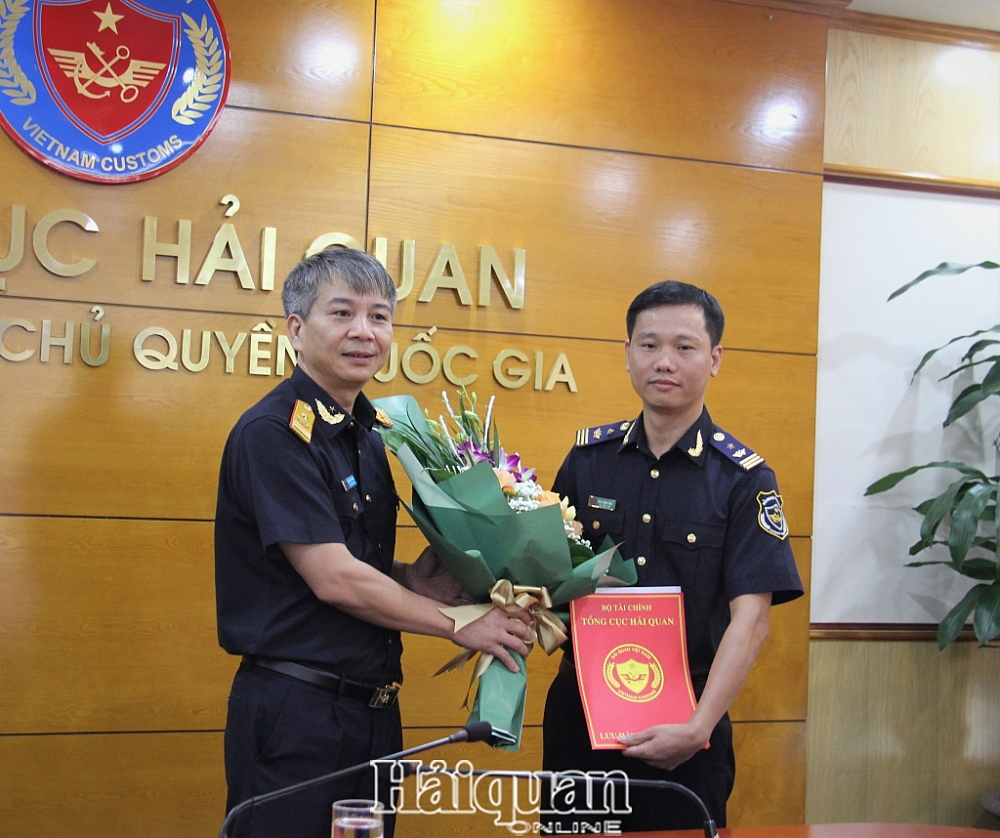 Thừa ủy quyền, Phó Tổng cục trưởng Mai Xuân Thành trao quyết định và tặng hoa chúc mừng tân Phó Vụ trưởng Vụ Pháp chế Đào Thịnh Vinh. Ảnh: H.Nụ