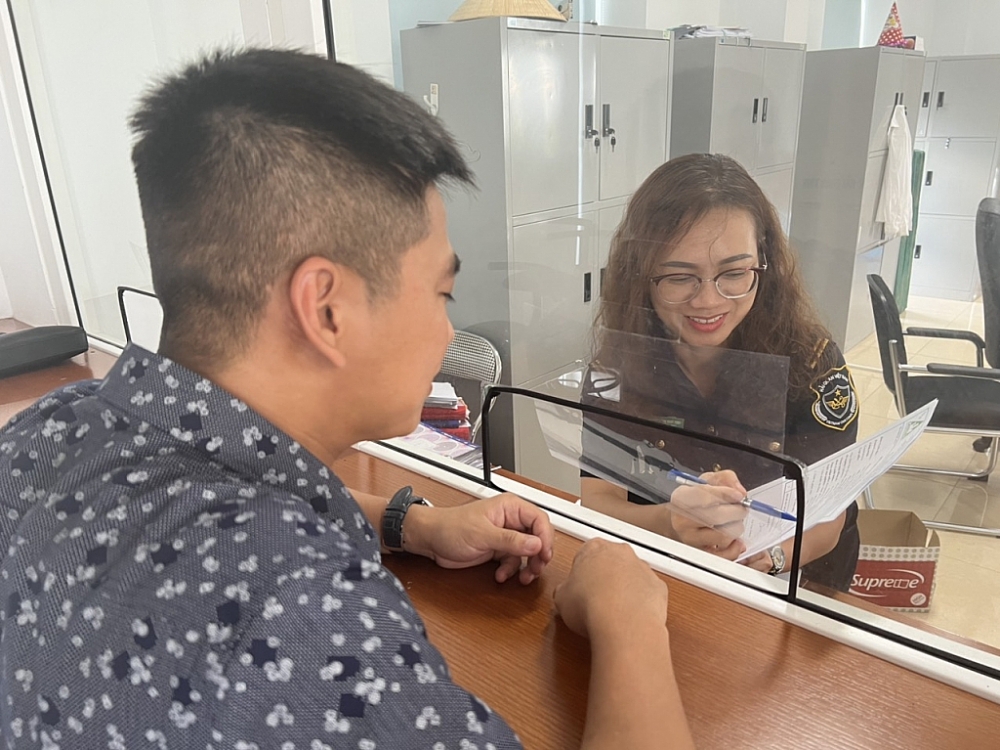 Công chức Hải quan Vinh (Nghệ An) hướng dẫn DN làm thủ tục hải quan. Ảnh: H.Nụ