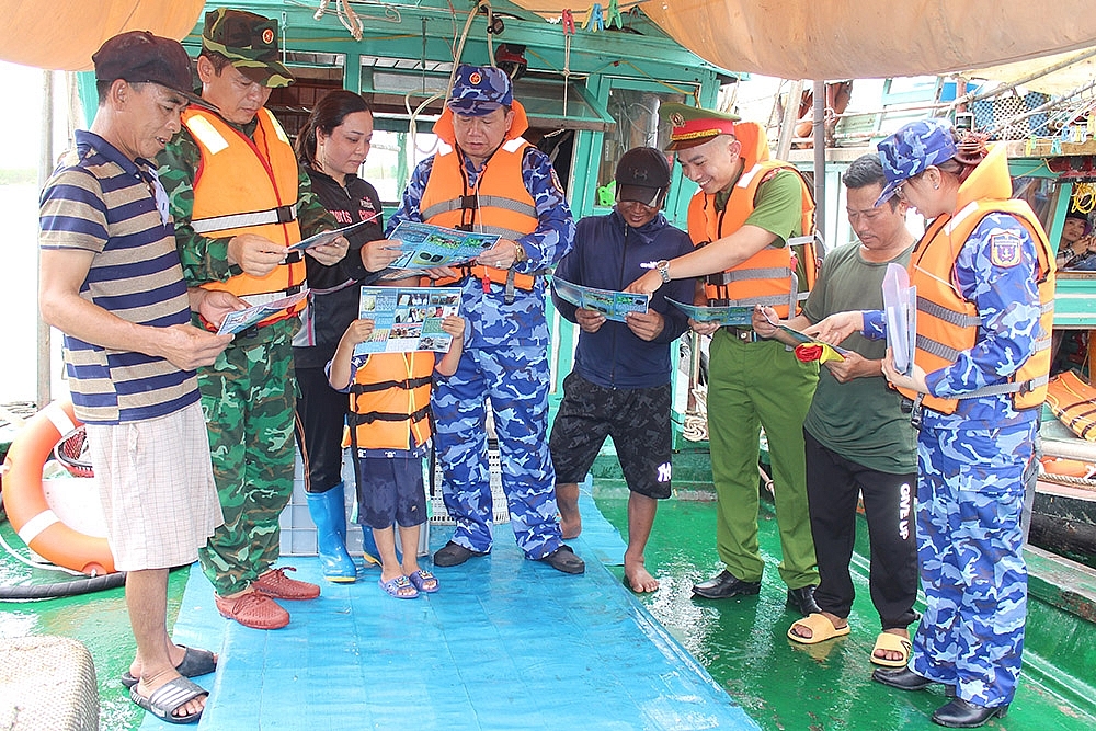 Lực lượng Cảnh sát biển tổ chức tuyên truyền, phát tờ rơi trực tiếp cho ngư dân tại các cảng. Ảnh: Mạnh Thường