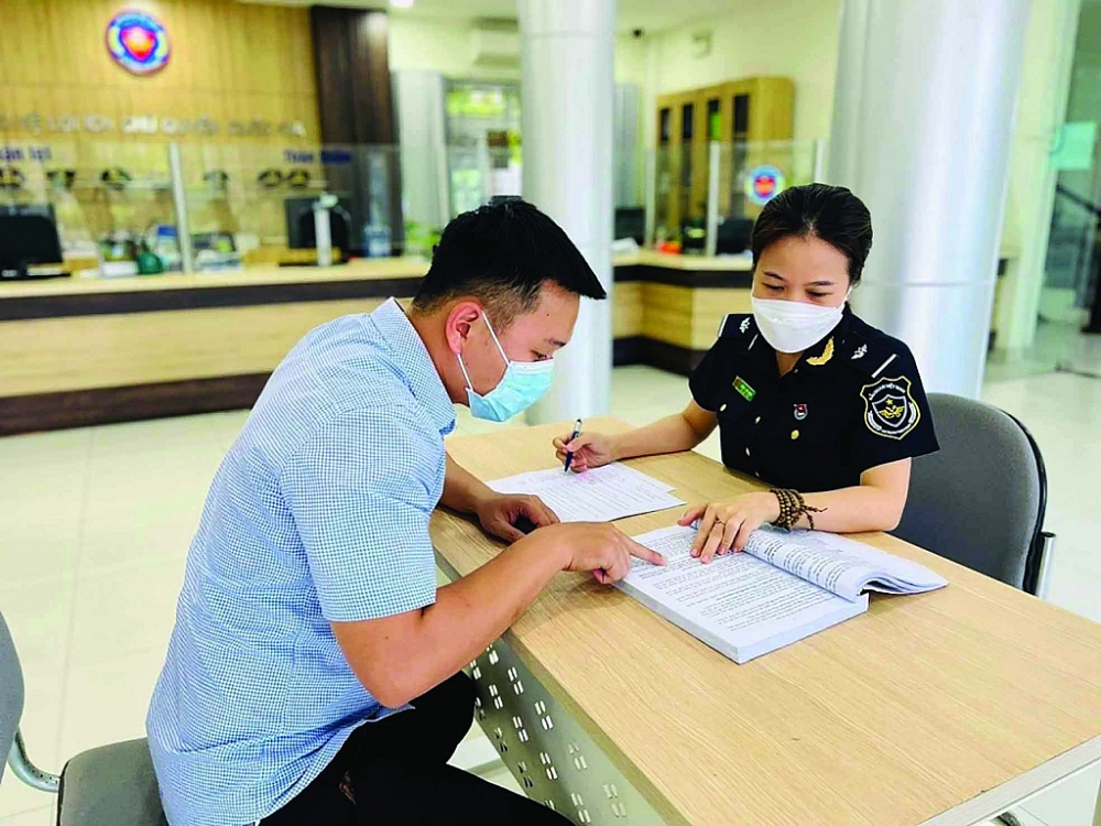 Công chức Chi cục Hải quan KCN Hòa Khánh - Liên Chiểu hướng dẫn thủ tục hải quan cho doanh nghiệp. 	 Ảnh: HQĐN