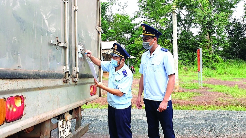 Công chức Chi cục Hải quan Lộc Thịnh giám sát hàng XNK, 2021. 	Ảnh: Đăng Nguyên 